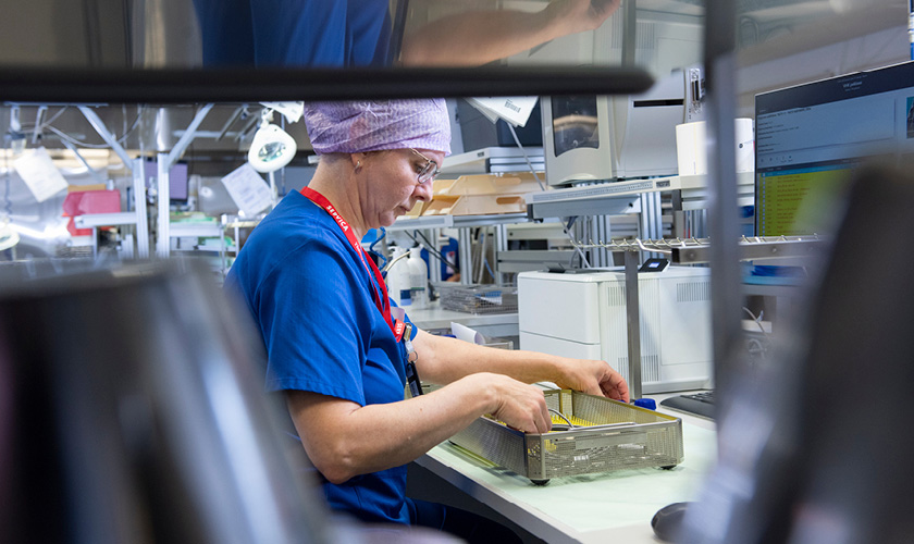 An employee of Servica's sterile processing services inspects and maintains the instruments in the sterile processing centre.